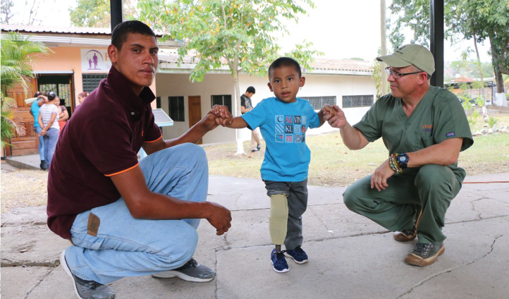 image of a boy standing with his father and a doctor